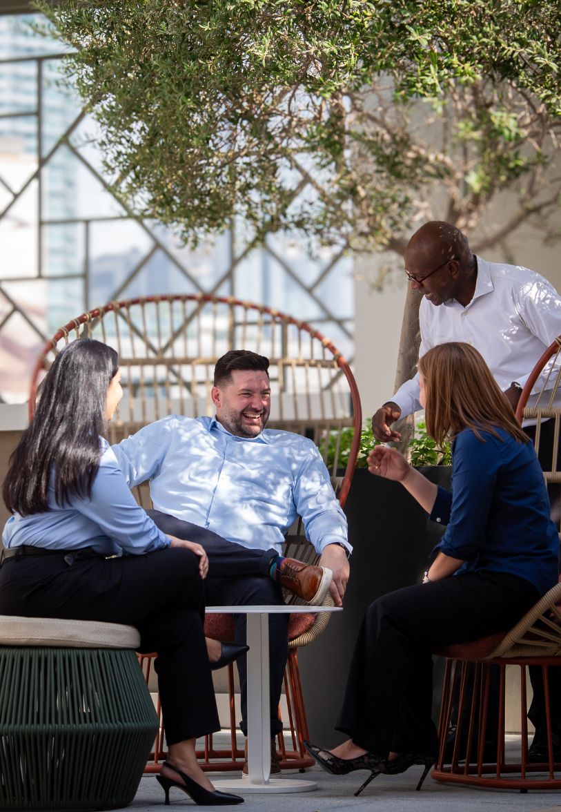 Colleagues enjoying informal coaching conversation outdoors during training break.
