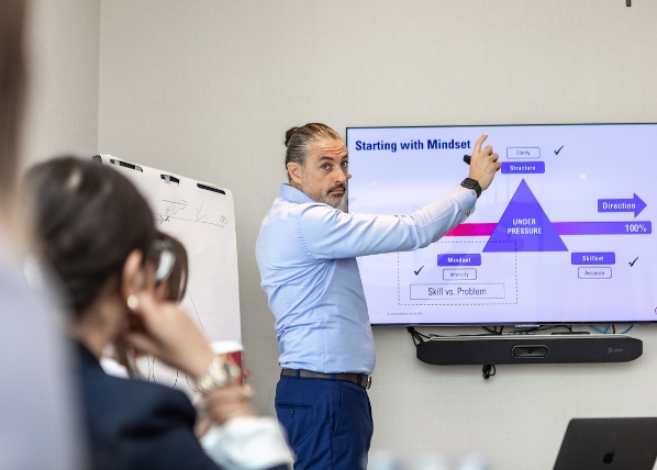 Ignite presentation skills course with trainer showing slide on screen.