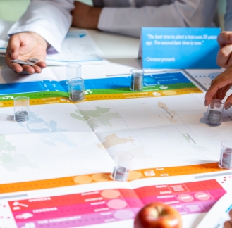 Hands-on team problem-solving training exercise with counters and worksheets.