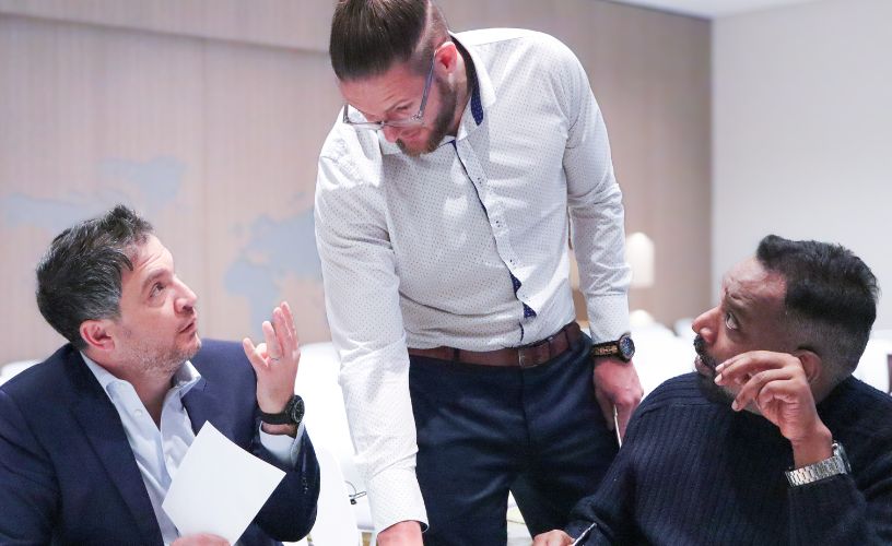 Professionals in a modern workplace navigating a discussion with calm and clarity, symbolising conflict management training.