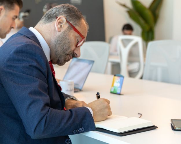 Business leader taking notes during leadership development training session in Dubai.