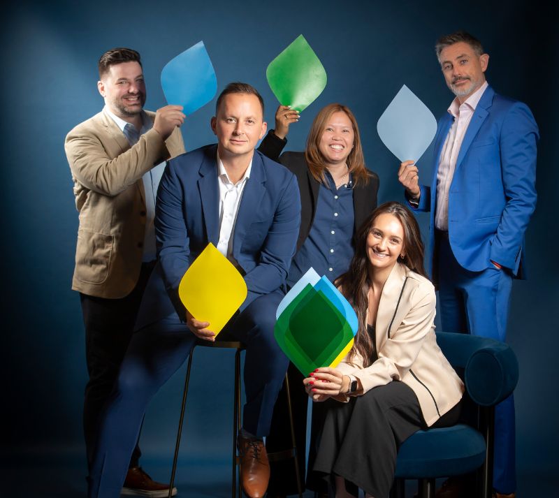 Ignite Training facilitators in Dubai holding brand colour cut-outs for team performance exercise.