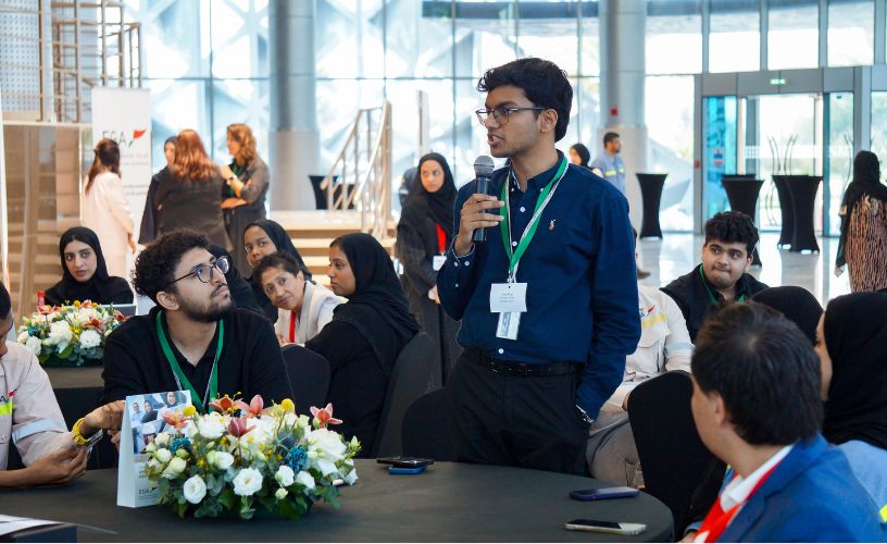Participant standing and speaking confidently with a microphone during a leadership training session.