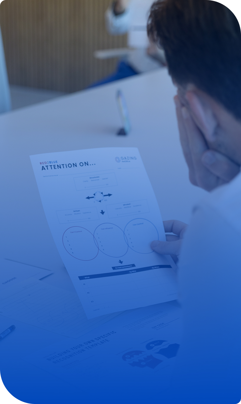 Participant reviewing Red2Blue leadership training handout on performance under pressure.